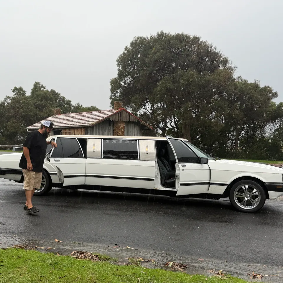 Grant standing next to the courtesy limo service vehicle