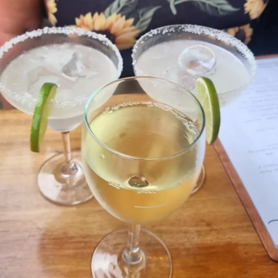 Wine glasses and margaritas arranged on table